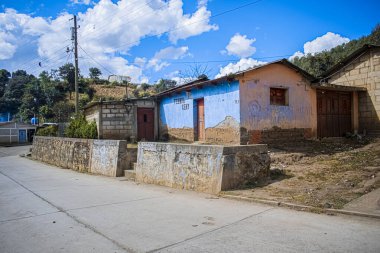 Yol kenarında mavi gökyüzü olan bir ev.