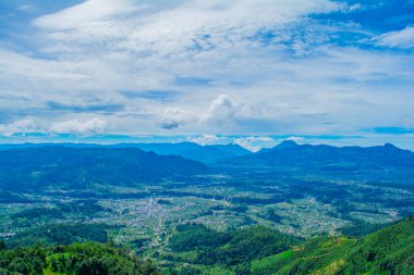 Beyaz bulutlu ve volkanlı dağları olan cajola şehri ile vadi manzarası