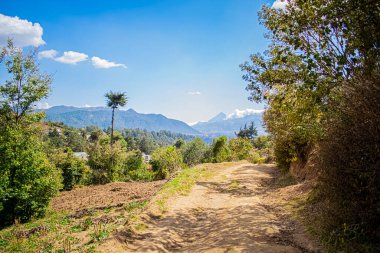 Dağlı toprak yol, mavi gökyüzü.