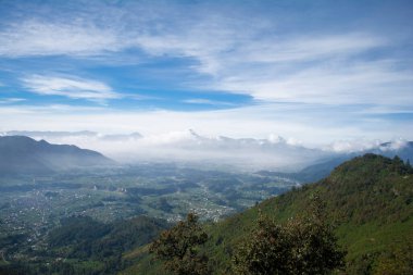 Ormanda dağlarla birlikte bulutların yükseldiği vadi manzarası