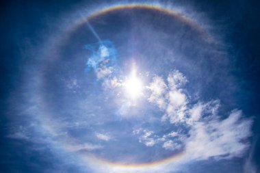 Güneş ışınları beyaz bulutlar ve güneş tutulması.