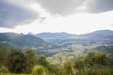 Dağları ve beyaz yağmur bulutları olan güzel bir vadi.