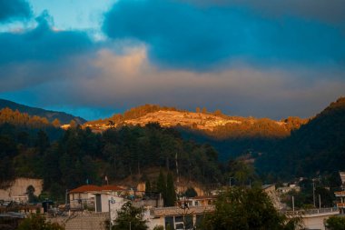 Günbatımı güneşli ev ve bulutlu hava yansımaları.