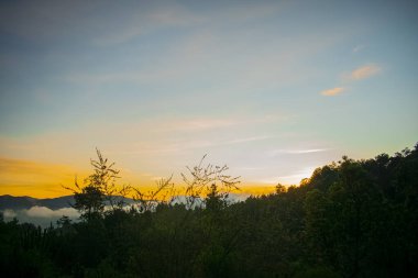 bahar manzarası kırmızı bulutlar ve dağlardan ve ağaçlardan oluşan siluet