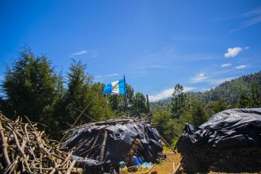 Siyah tuvalin altında bayrak ve güzel mavi gökyüzü okunuyor.