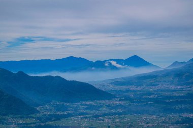 Dağlarla çevrili köylerle dolu güzel vadi manzaralı yağmurlu hava