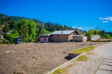 Mavi gökyüzü ile kerpiç yapılmış kuru tarlada bir ev