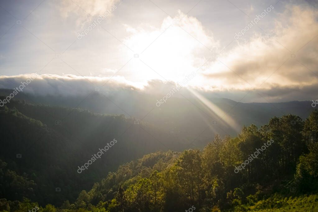 sunrise with sun shining mountains with tropical jungle