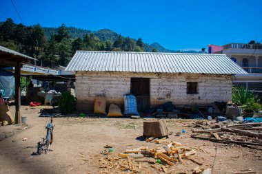Önünde çuval ve bavul olan eski kerpiç evi.