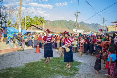 İki kadın tipik bir cajola kostümüyle dans ediyor ve insanlar olayı izliyor.