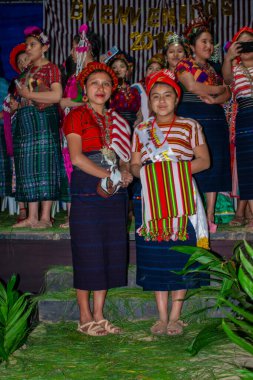 Cajola kostümlü iki kadın ve arka planda insanlar olan San Juan Ostuncalco.