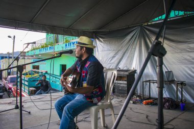Elinde gitarıyla genç bir adam ve tipik bir cajola kostümü.