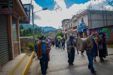 Davul ve diğer el kalkanı taşıyan bir adam sokakta yürüyor.