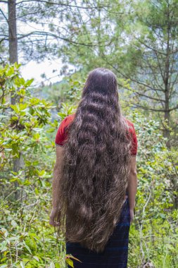 Yeşil ormanın ortasında yaşayan yerli Maya kadınının uzun saçları.