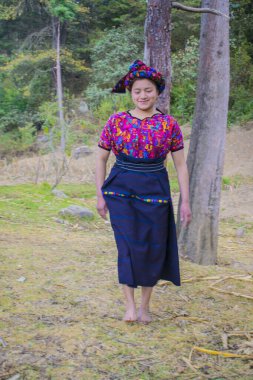 Yerli Maya kadını tipik bir Chiquirichapa kostümüyle yürüyor.