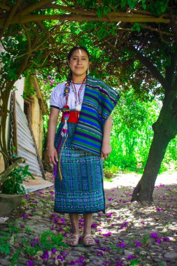 Ormanda tipik bir kostümle yürüyen bir kadın.