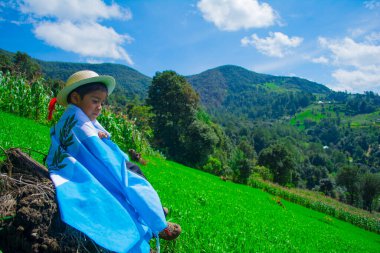 Guatemala bayrağı ve manzara geçmişi olan bir çocuk profilde oturuyor.