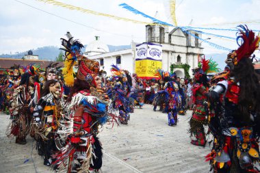 Kilisenin önündeki cajola fuarında kostümlü insanlar dans ediyor.