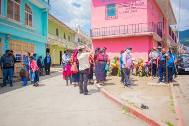Maya yerlisi kadınlar ellerinde çiçeklerle Cajola caddesinde Maya sunağında dururlar.