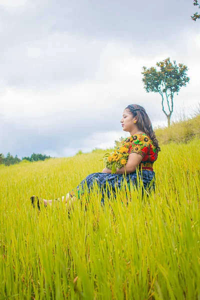 身着典型玛雅人服装的女人坐在绿草如茵 绿树成荫的草地上 — 图库照片