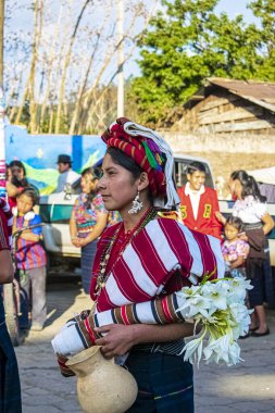 Tipik cajola kostümlü kadın arka planda insanlarla sokakta dans ediyor.