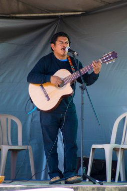 Sahnede gri arka planda muska çalan bir adam var.