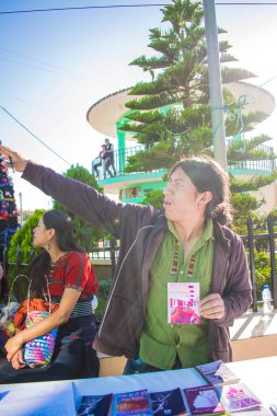Elleri gökyüzüne uzanan ve arka planda ağaçlar olan genç bir adam.