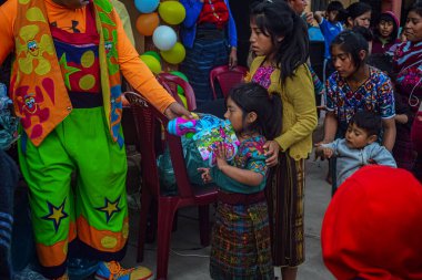 Kız yılbaşı hediyesini arka plan balonlarıyla alıyor.