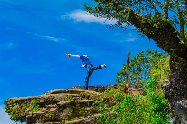 Junger Mann Springt Mit Blauer Kleidung Auf Felsen Und Baum — Stockfoto