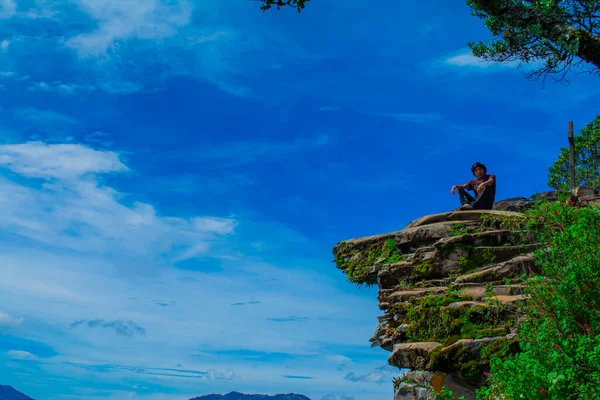 Colina Con Hombre Joven Sentado Mirando Valle Con Cielo Azul —  Fotos de Stock