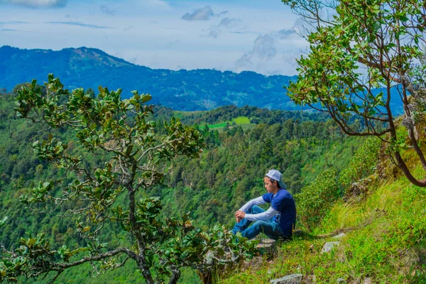 Junger Mann Sitzt Mit Grünen Bäumen Mit Weißen Wolken — Stockfoto
