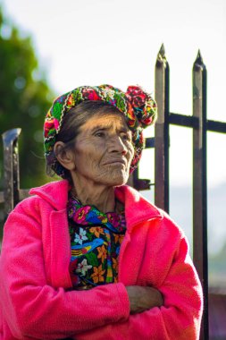 Mayan indigenous old woman with headband sitting clipart