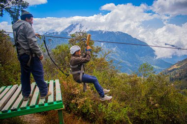 Genç adam arka plan vadisi ve beyaz bulutlarla gölgeye atlıyor.
