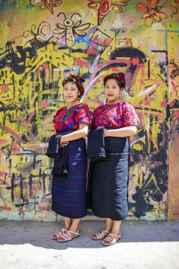 Arka plan duvarı ve kafa bandı ile duran güzel kadınlar.