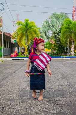 Cajola 'dan tipik Maya kıyafetleriyle yürüyen güzel bir kız profiline bakıyor.