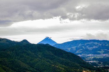 Doğal ormanı ve beyaz bulutları olan volkanlar