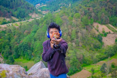 Geniş elli ve orman yeşili geçmişi olan genç bir adam.