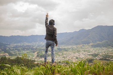Arka planda vadi kasabası olan genç eller gökyüzünde
