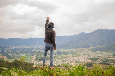 Siyah elbiseli ve bulutlu genç eller gökyüzüne