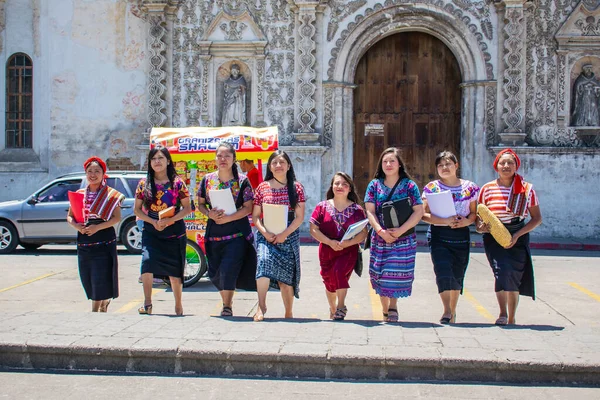 Kilisenin önünde tipik Maya kostümüyle yürüyen kadınlar.