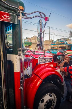 Kırmızı otobüs terminalde insanlarla ayrılıyor.