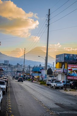 Araba yolda, arka planda volkanlar var.
