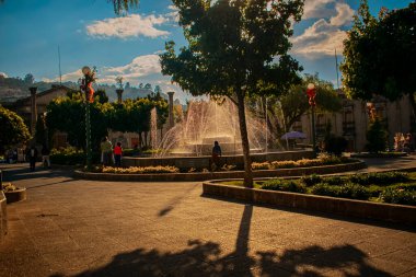 Sokakta yürüyen insanların olduğu güzel Xela Parkı