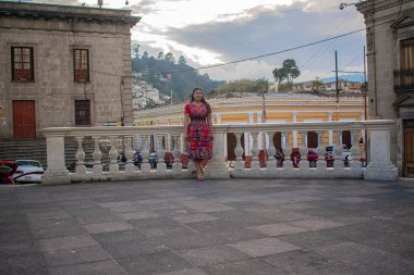 Tipik kostümlü güzel bir kadın eski şehir parkında duruyor.