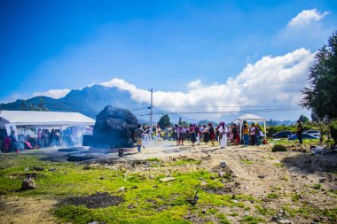 Maya töreni yapan insanlarla dolu bir dağ manzarası.