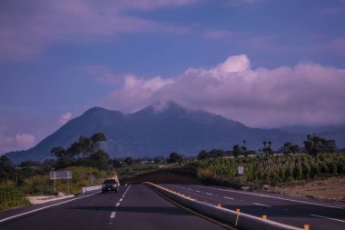 Dağlı ve beyaz bulutlu yol manzarası