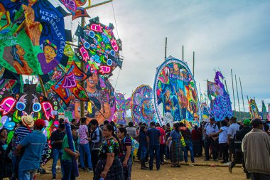 Gökyüzü bulutlu büyük renkli uçurtmalar ve insanlar 1 Kasım 2018 'de Sacatepesquez, Guatemala' yı takdir ediyor.
