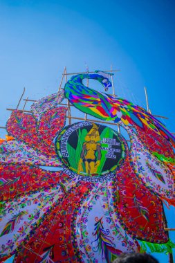 Büyük renkli uçurtmalar mavi gökyüzü ve kabile figürleri.