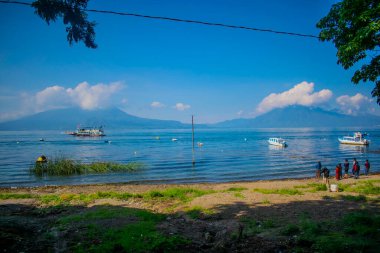 beautiful lake of atitlan, with boats around with a beautiful background clipart