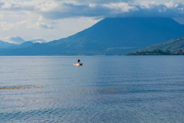 Arka planda güzel bir volkan olan Atitlan Gölü.